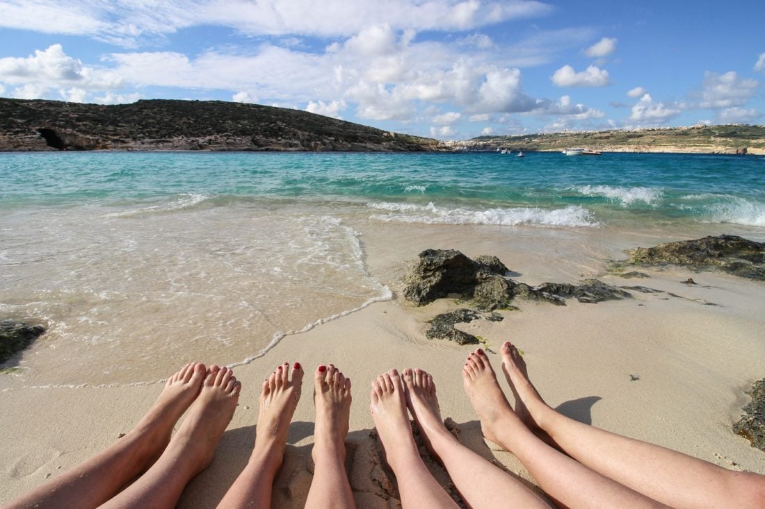 4 girls sitting right by the water at the Blue Lagoon in Malta