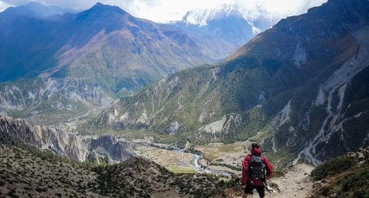 Man looks down at Manang on the Annapurna trail in Nepal
