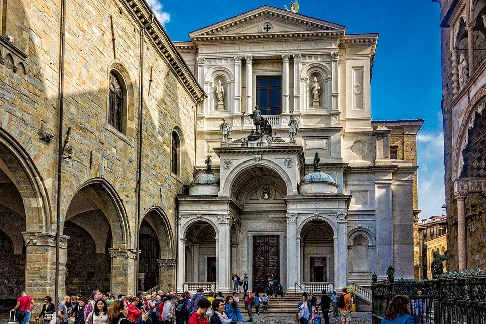 People sitting on the steps of a church in Bergamo, Italy. 