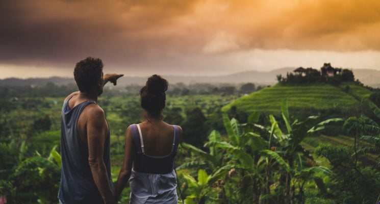 man and woman looking over a lush green landscape in Bali on one of the best Bali tours