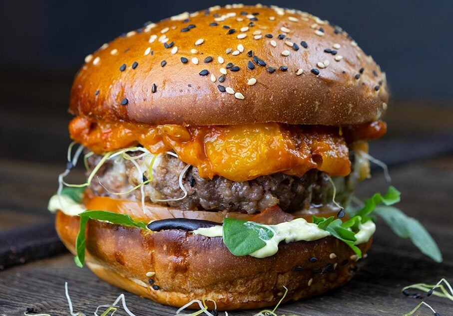 A cheeseburger on a wooden board. 