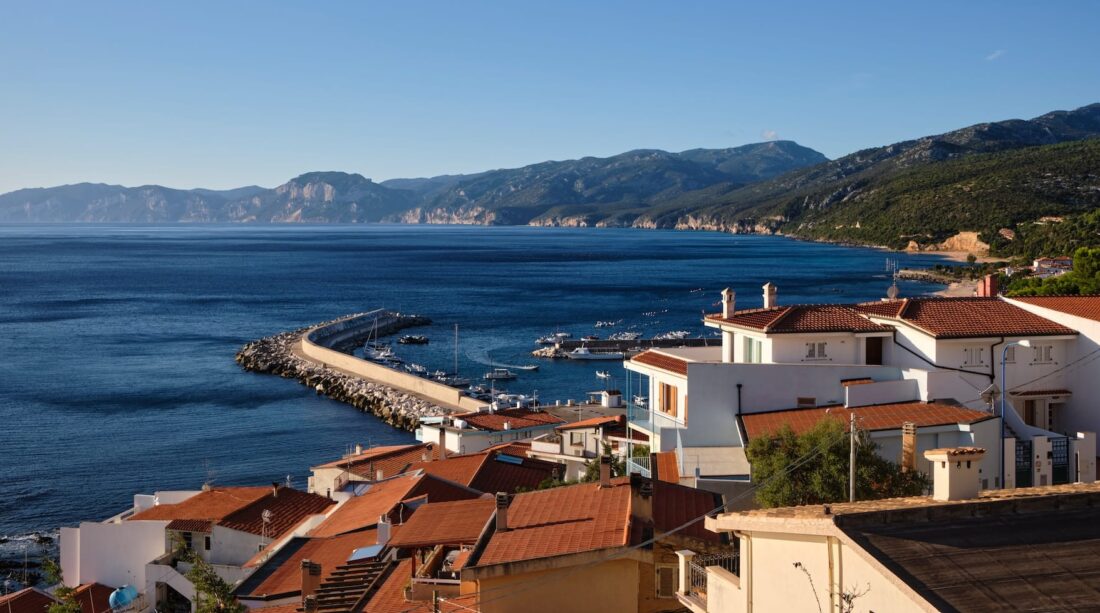 Rooftops and a pier by the shore in Nuoro, Italy.
