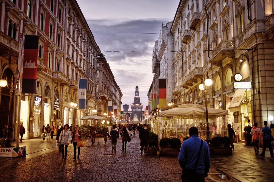 People walking around Milan's downtown during a autumn evening.