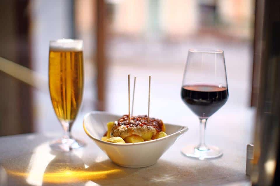 Wine, beer, and a bowl of tapas on a table in El 58 Tapas Bar, Barcelona