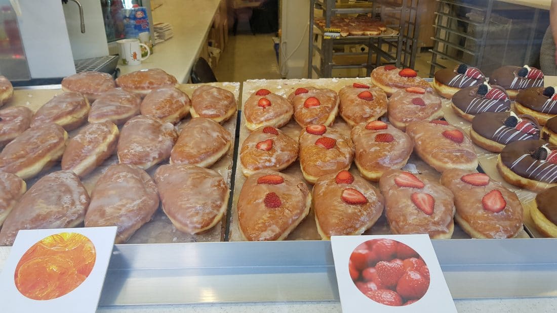 pączki, fried pockets of dough stuffed with delicious goodies, displayed in a shop window inWroclaw