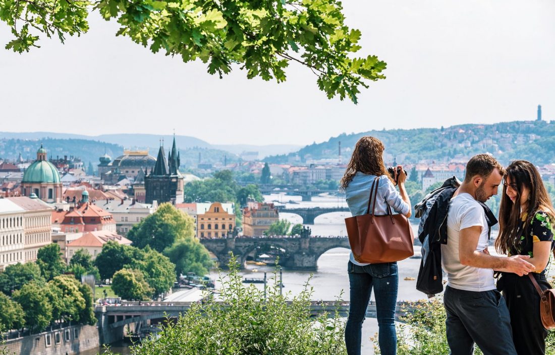 three people looking out over the river and bridges of Prague from Letna Park