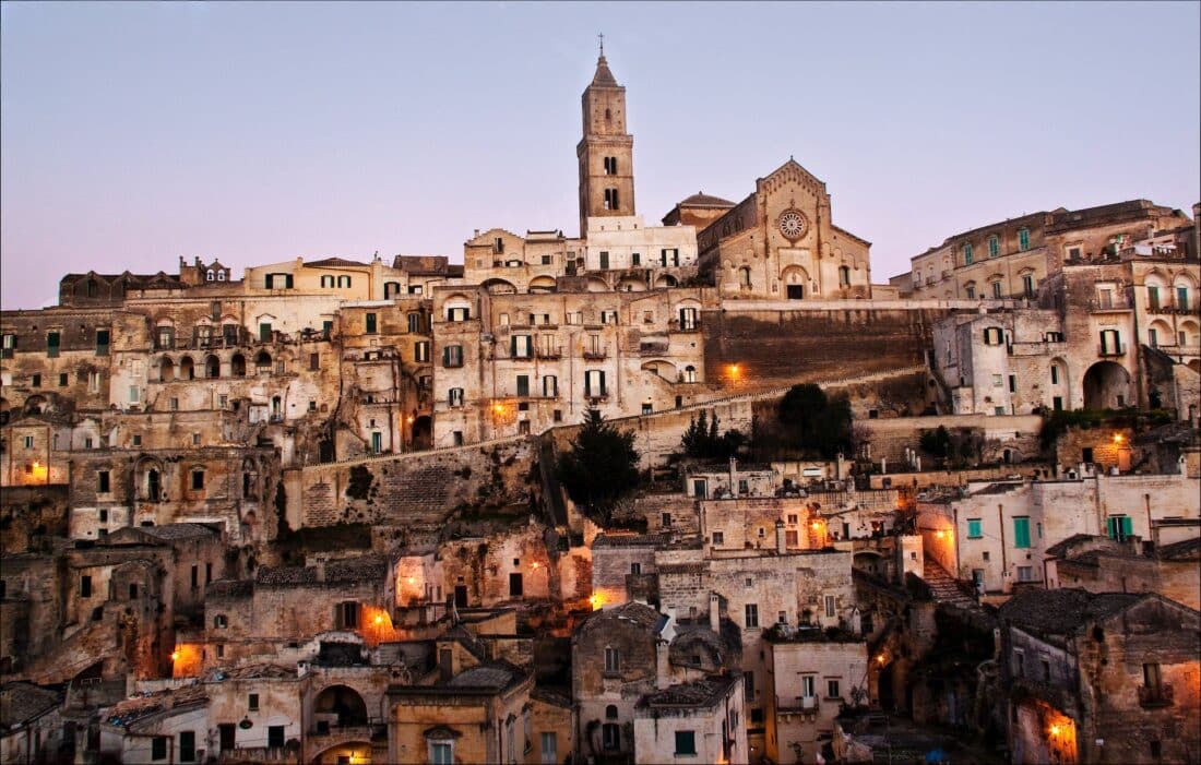 Rooftops and towers with lights coming on in the evening in Matera, Italy
