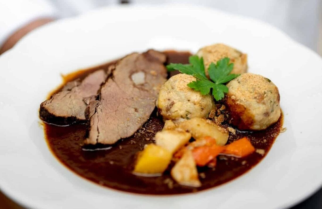 Beef and dumplings on a plate in Prague